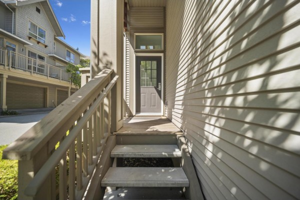 View of wooden stairs leading to a grey front door of a townhouse. - 45 2738 158 Street, Surrey