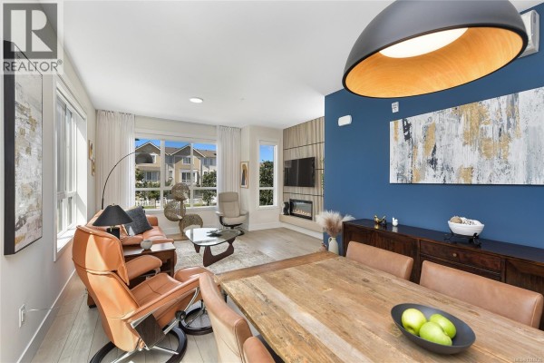 Dining area with a rustic wooden table and chairs, a dark wood sideboard, and a view into the living room. - 45 368 Tradewinds Ave, Colwood