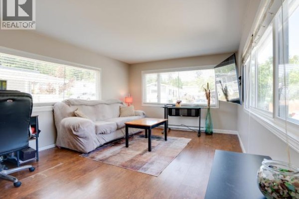 Living area with light blue sofa and hallway entrance with stairs. - 45-4500 Claridge Road, Powell River