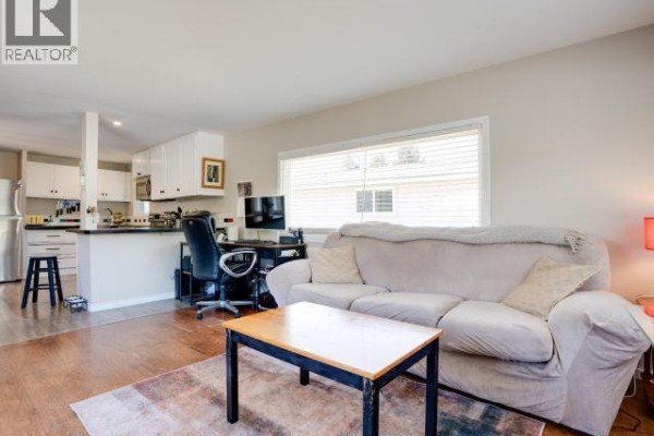 Deck with patio furniture and colorful rug overlooking a grassy yard. - 45-4500 Claridge Road, Powell River
