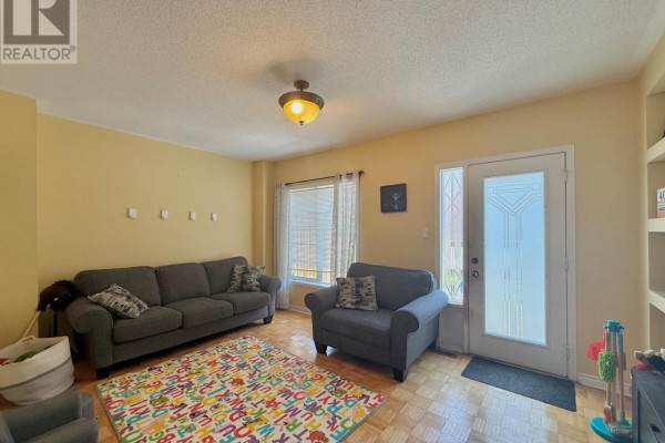 Living room with two sofas, a chair, and a large colorful rug on the parquet floor. - 45 Carrillo Street, Vaughan