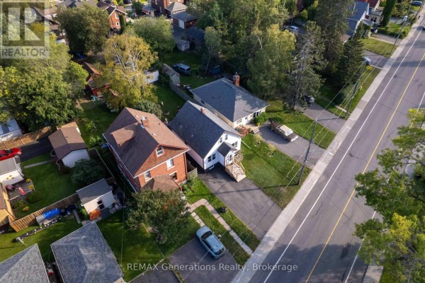 Aerial view showing multiple residential houses and a long paved road on the right side. - 45 High Street N, Thunder Bay