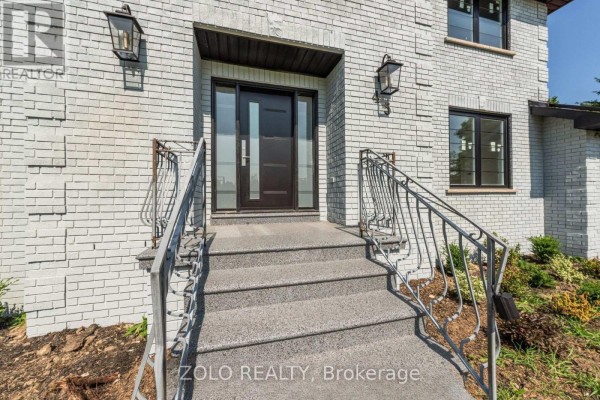 Bright and spacious foyer with white doors, marble tile flooring, and a dark wood staircase. - 45 Hilda Road, King