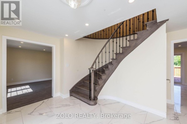 A living room with a modern electric fireplace, large windows, and access to a wooden deck. - 45 Hilda Road, King
