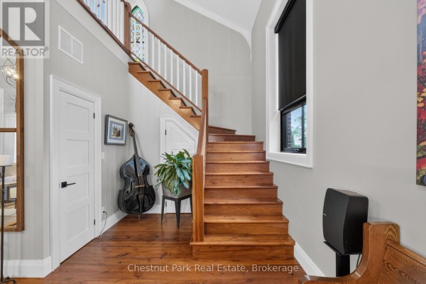Wooden staircase with white railing and doors on the left. - 45 Mcmurray Street, Bracebridge