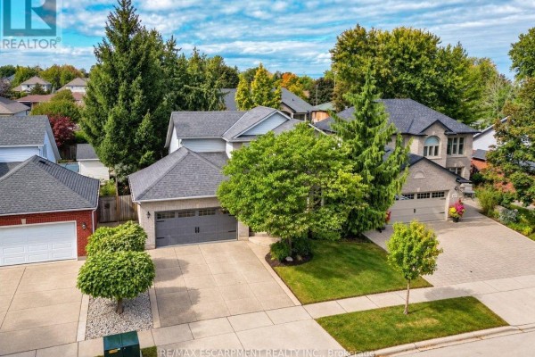 Aerial view of a suburban street with several houses, garages, and mature trees. - 45 Richmond Crescent, Hamilton