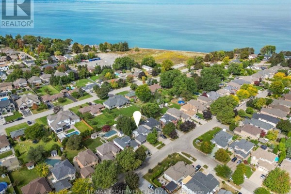 Aerial view of a residential neighborhood with houses and a large body of water in the background. - 45 Richmond Crescent, Hamilton