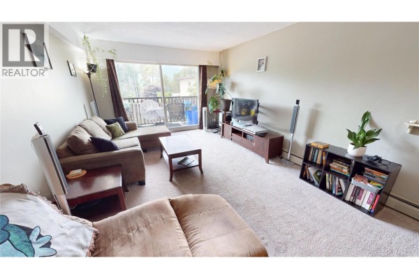 Living room furniture including a sofa, coffee table, and entertainment center. - 45 Ridgemont Drive Unit# 302, Fernie