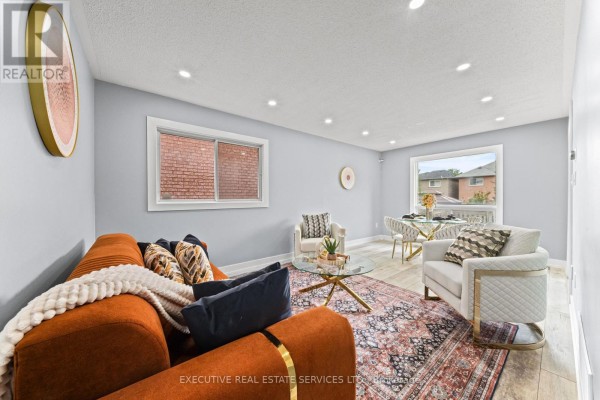 Orange sofa, glass coffee table, dining set, and area rug in a modern living room - 45 Sahara Trail Brampton