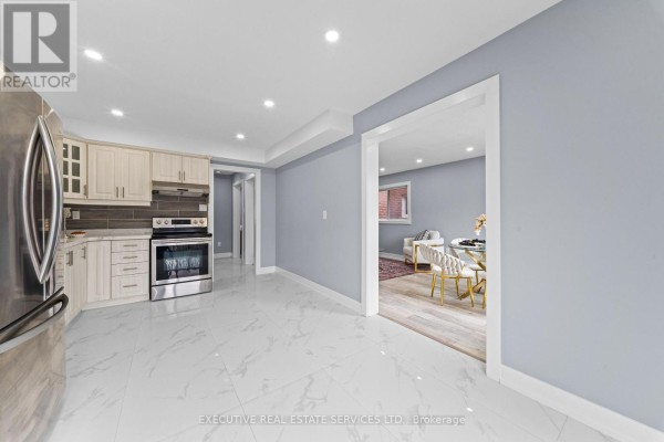 Modern kitchen with stainless steel appliances & tile flooring - 45 Sahara Trail Brampton
