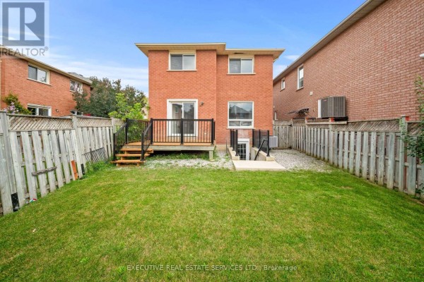Brick house backyard with deck, stairs, fence, and basement entrance - 45 Sahara Trail Brampton
