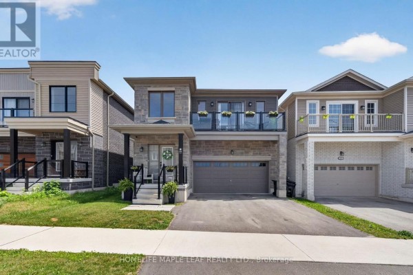 Modern two-story house exterior with stone and dark siding, balconies, and a two-car garage under a blue sky. - 45 Wheatfield Road, Barrie