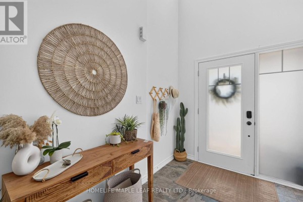 Bright entryway with white walls, a wooden console table, bench, and glass front door with a decorative wreath. - 45 Wheatfield Road, Barrie