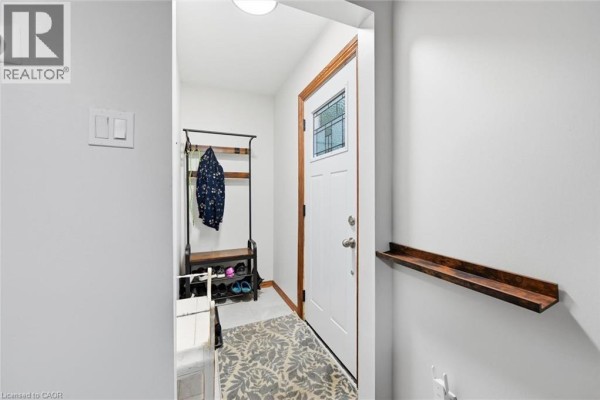 Interior foyer with white door, wood trim, shoe rack, bench, and coat rack. - 450 East 42nd Street, Hamilton