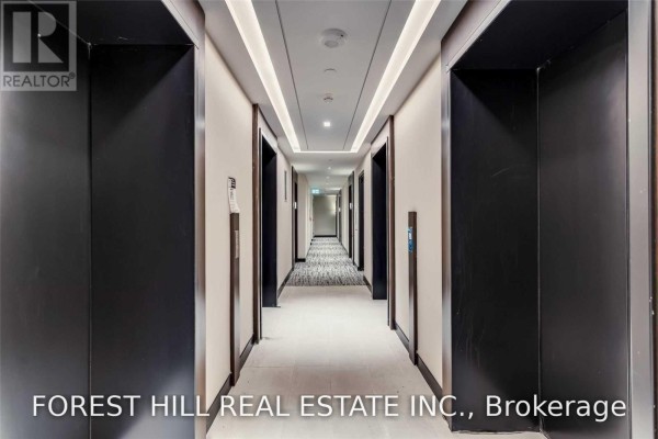 Hallway of a modern apartment building with black elevators and carpeted floor. - 4505 - 2221 Yonge Street, Toronto