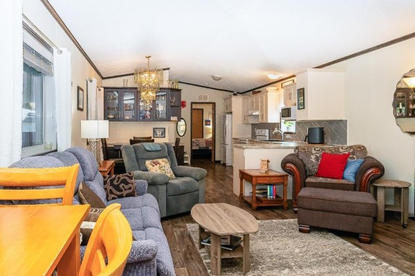Living room with seating area, dining table, and kitchen in background - 4505 Mclean Creek Road Unit# C11, Okanagan Falls