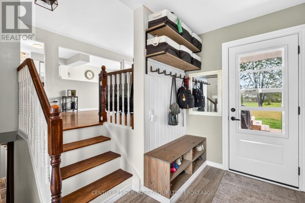 Entryway featuring a staircase, white beadboard wall, storage shelves, hooks, and a bench. - 4505 Susan Drive, Elizabethtown Kitley