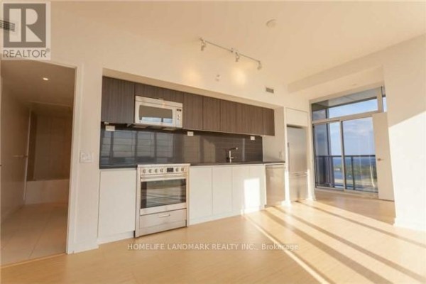 Modern kitchen with stainless steel appliances, dark backsplash, and light wood floors. - 4506 - 85 Queens Wharf Road, Toronto