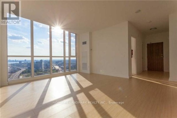 Living area with expansive windows showing city views and light wood floors. - 4506 - 85 Queens Wharf Road, Toronto
