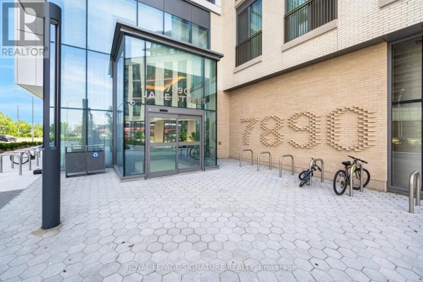 Entrance to apartment building 7890 Jane Street with automatic glass doors and bicycle racks outside. - 4508 - 7890 Jane Street, Vaughan
