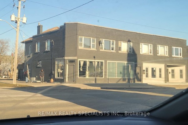 Exterior corner view of a multi-level brick building with large windows on Simcoe Street, Oshawa. - 451 Simcoe Street, Oshawa