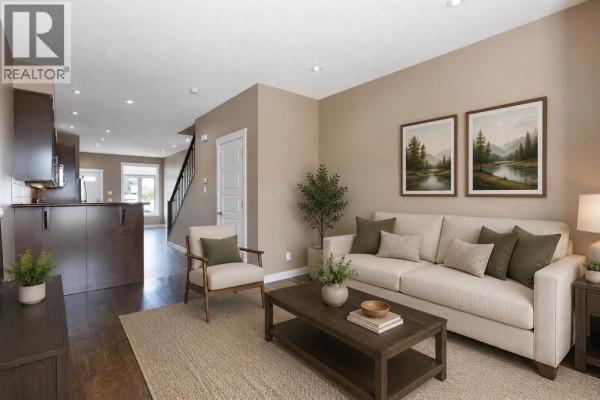 Living room with a beige sofa, accent chair, coffee table, and two landscape paintings. - 4510 73 Street Nw, Calgary