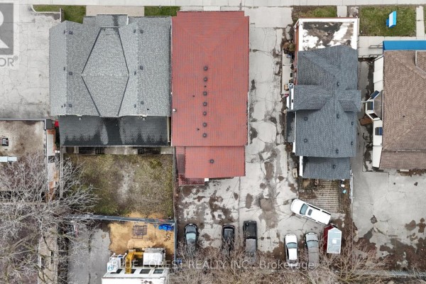 Top-down aerial view of a commercial building with a red shingle roof, flanked by residential properties and a parking area. - 452 Horton Street, London East