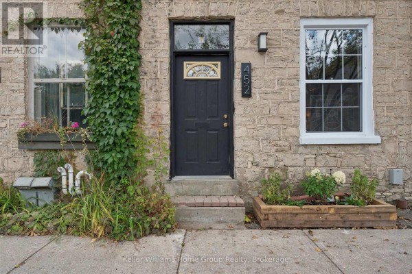 Close-up of the entrance to townhouse 452, featuring a black door with glass and stone facade. - 452 St Andrew Street W, Centre Wellington