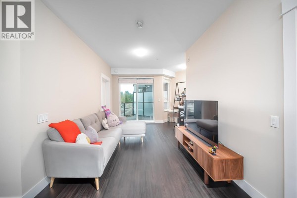 Wide view of the living room, showing the sofa, media console, and a doorway to the balcony. - 4520 2180 Kelly Avenue, Port Coquitlam