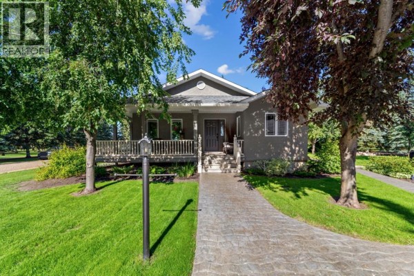 Side view of the house showing the porch and surrounding trees. - 45217 Range Road 202, Rural Camrose County