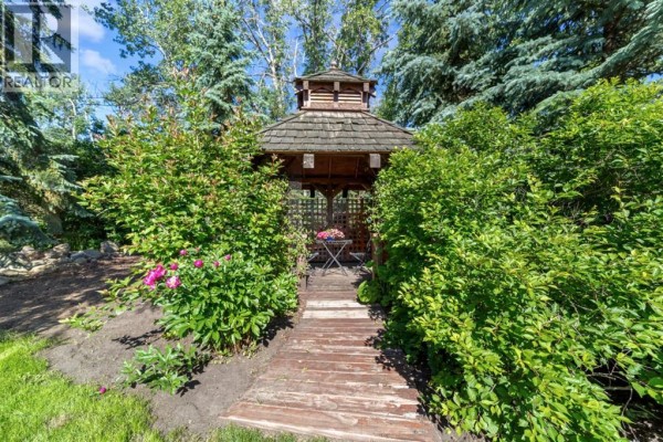Covered porch with two wicker chairs and a hanging planter. - 45217 Range Road 202, Rural Camrose County