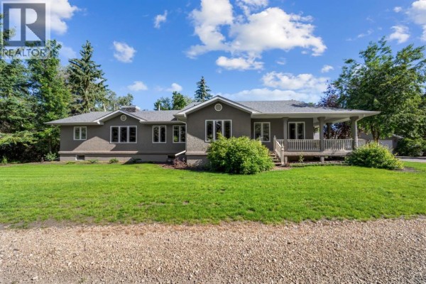 Interior entryway with wooden railing, light fixture, and access to living area. - 45217 Range Road 202, Rural Camrose County