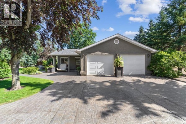 Living room with brown sofas, coffee table, and large windows overlooking the yard. - 45217 Range Road 202, Rural Camrose County