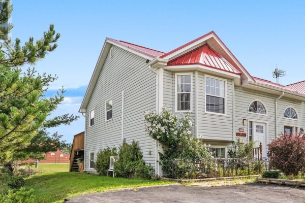 Open-concept living and dining area with light wood floors, a dining table, sofa, and television. - 453 Young Street, Truro