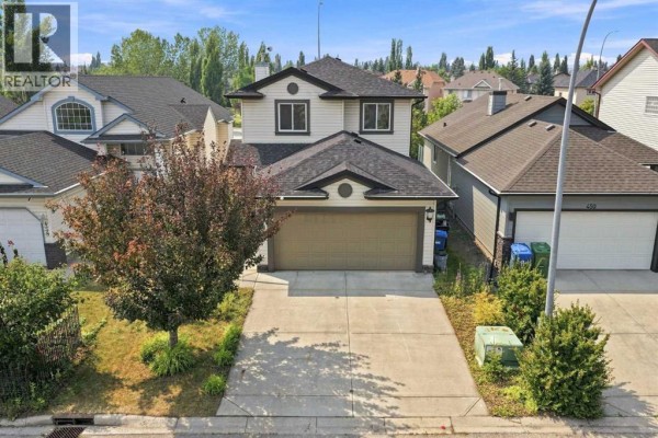 Aerial view of the front of the house with a driveway and lawn. - 454 Millrise Square Sw, Calgary