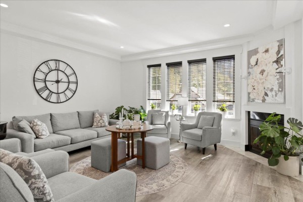 Spacious living room with gray sofa, armchairs, and a large wall clock. - 45425 Ariel Place, Vedder Mountain, Cultus Lake