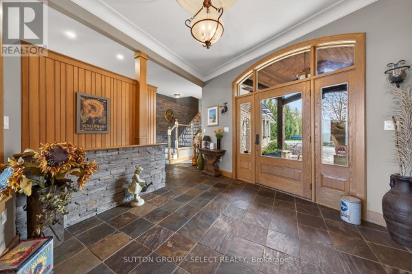 Entrance foyer with slate tile floor, wood paneling, and glass double doors. - 4544 Lakeshore Road, Plympton Wyoming