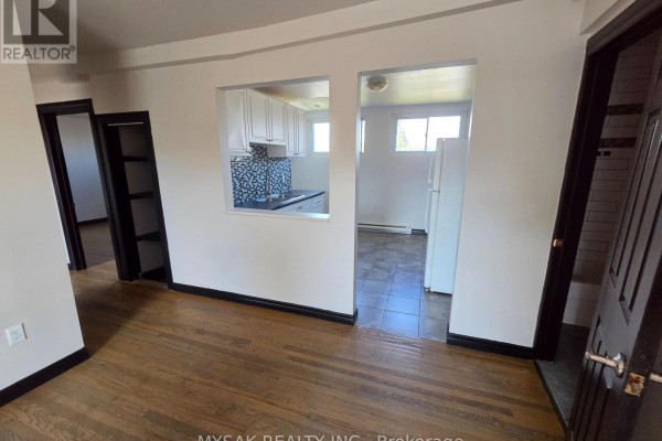 View of living area and hallway, with openings to kitchen and another room. - 455 King William Street, Hamilton