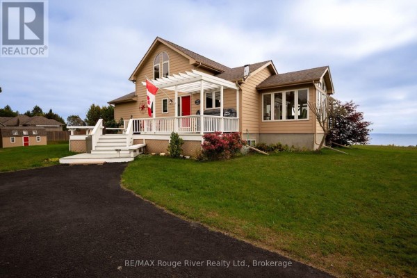 Front exterior of a tan house with white trim, a red door, and white deck with pergolas. - 455 Lakeshore Road, Alnwick/haldimand