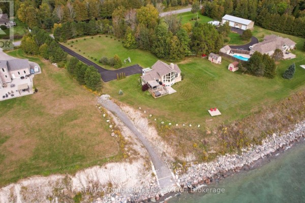 Aerial view of the property at 455 Lakeshore Road, showing the house, lawn, driveway, and shoreline. - 455 Lakeshore Road, Alnwick/haldimand