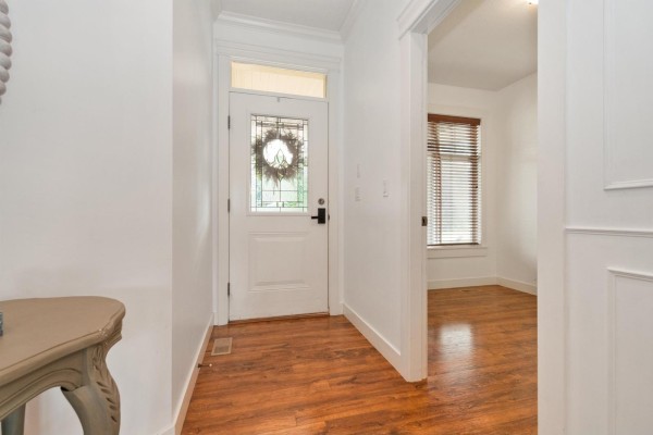 Interior entryway with white walls, wood flooring, and view to a room. - 45517 Wells Road, Sardis West Vedder, Chilliwack