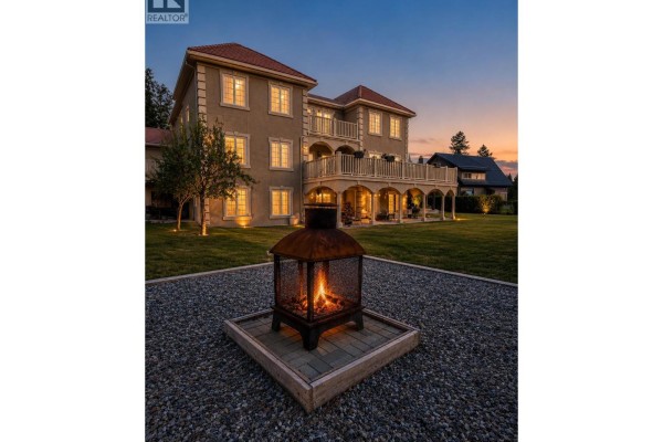 Backyard with a fire pit, patio, lawn, and view of the house at dusk. - 456 Lakeview Road, Invermere
