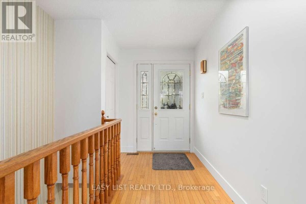 Close-up of the front door featuring decorative glass and wooden carvings on either side. - 456 Old Surrey Lane, Kawartha Lakes