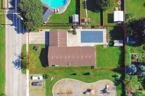 Aerial view of a large property with a swimming pool, fenced backyard, and attached garage. - 456 Saulsbury Street, Strathroy Caradoc