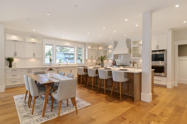 Large kitchen island with seating, dining table, and white cabinetry throughout. - 4560 198 Street, Langley