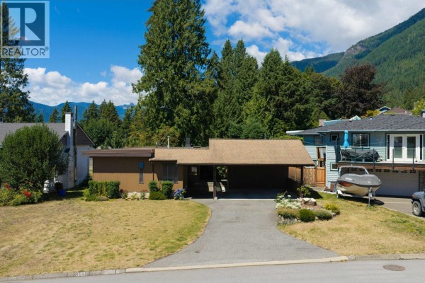 Aerial view of a single-family home with a carport and mountain backdrop. - 4568 Marineview Crescent, North Vancouver
