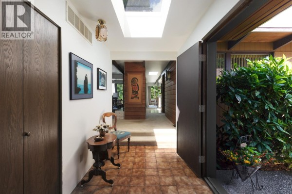 Interior entryway with tile floor, wood doors, artwork, and skylight. - 4568 Marineview Crescent, North Vancouver