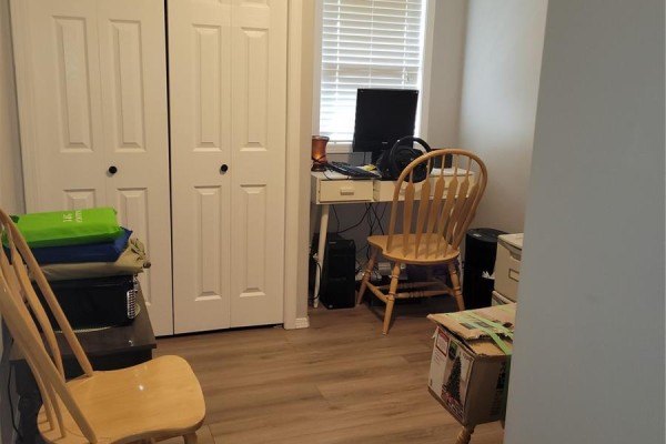 Small office space with a desk, computer, and chairs. Wood-look flooring and double doors. - 457 Brooklyn Crescent, Warman