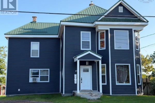 Front view of the multi-family house with a covered entrance and several windows. - 457 Robie Street, Truro
