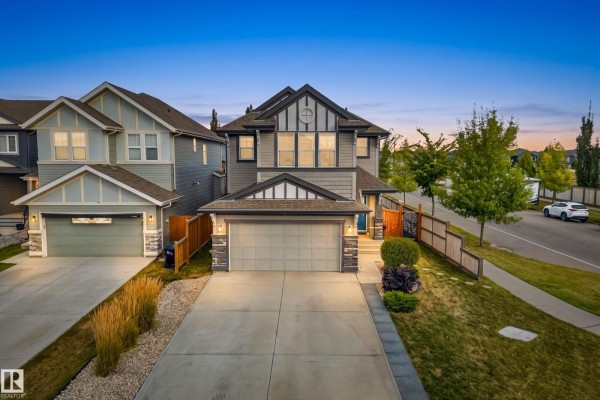 Exterior of a grey and white two-story house with a double garage, concrete driveway, and lawn. - 457 Still Creek Cr Nw, Sherwood Park